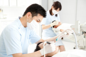 患者の治療を行う男性歯科医師