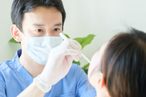 患者の口の中を診察する男性歯科医師