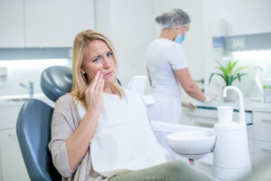 歯科医院で歯を抑える女性患者