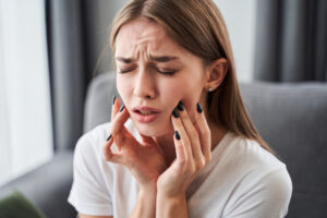 歯の痛みから顎を抑える女性