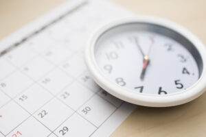 机に置かれたカレンダーと白い時計