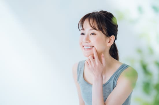 白い歯を指さし嬉しそうな女性